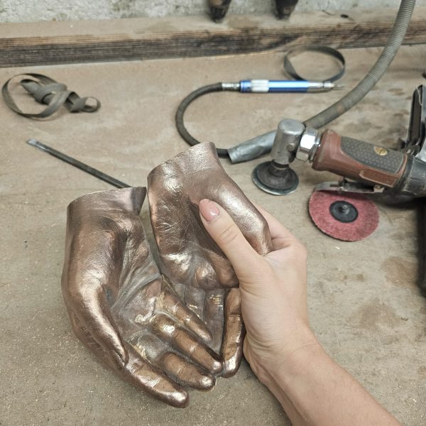 bronzen handen aan het afwerken