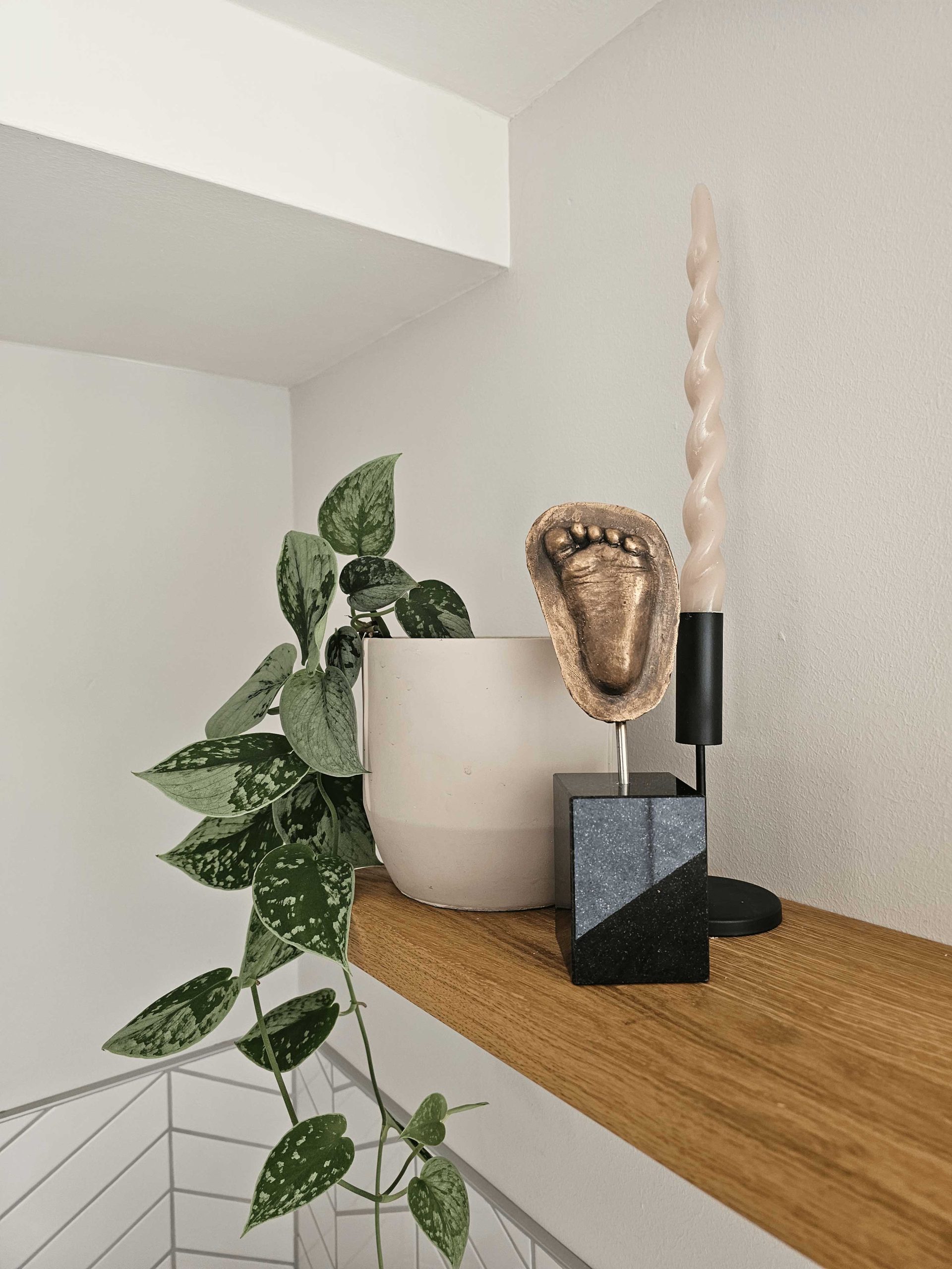 Voetafdruk in brons op zwarte sokkel