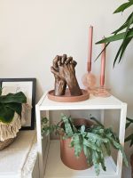 handbeeld van twee personen in bronskleur