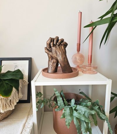 handbeeld van twee personen in bronskleur