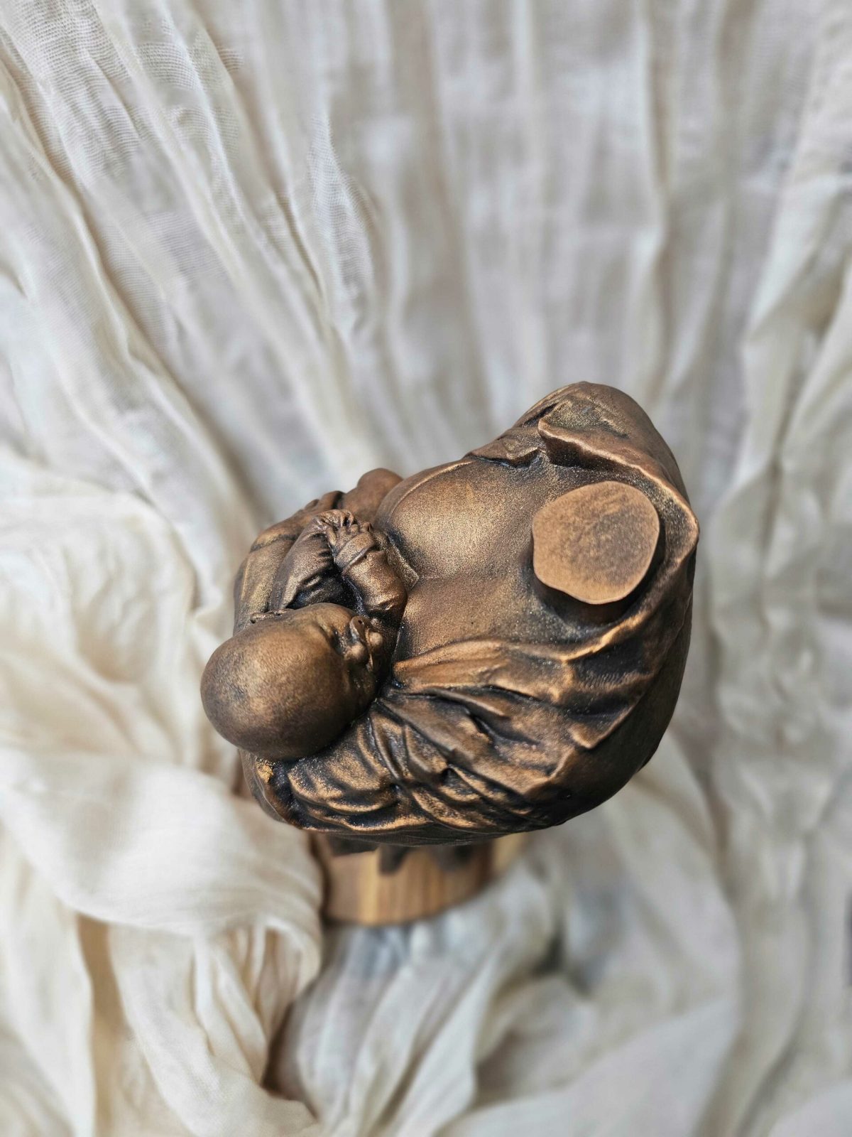 Beeld van moeder met kind in bronskleur