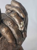 Gedenksieraad met handen afgedrukt in bronskleur plus bedel in zilver van het zelfde beeld